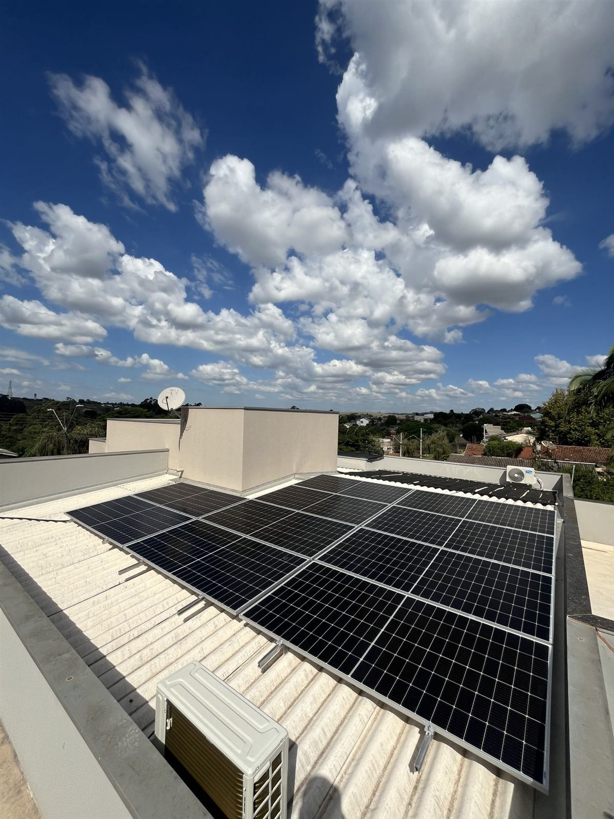 Painéis solares em telhado com céu azul